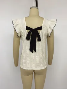 Strukturiertes weißes Strickoberteil mit Flügelärmeln und großer schwarzer Schleife am Rücken.