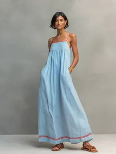Detalle de vestido largo a rayas azules y blancas con ribete rojo y tirantes finos