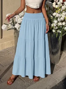 Detailed view of light blue smocked high waist tiered maxi skirt in a summer setting