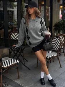 Elegante maglione grigio lavorato a maglia con rombi in un contesto casual all'aperto