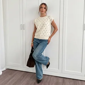 Schicker Strickwest-Pullover mit Punktmuster, kombiniert mit Jeans in hellem Raum