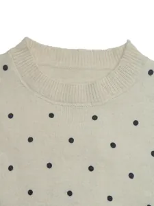 Detailansicht des Rundhalsausschnitts eines cremefarbenen Damen-Strickpullovers mit Punkten