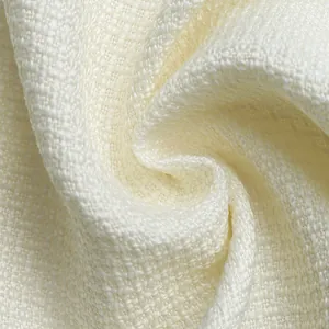 Macro detail showing the high-quality cream white textured fabric of the elegant dress