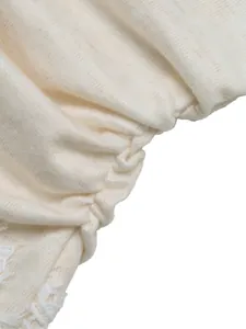 Detailed macro view of cream ribbed knit fabric and delicate white lace trim