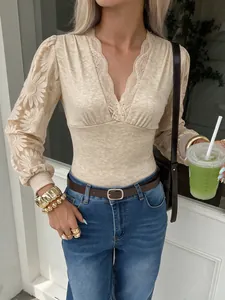 Primer plano de un elegante body beige con mangas largas de encaje y cuello en V femenino