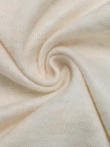 Detailed macro shot of soft cream-colored knitted fabric showing its fine texture