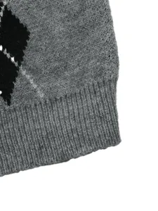 Dettaglio macro di un maglione grigio a rombi in maglia con bordo a costine.
