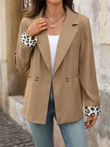 Detailopname van een camel damesblazer met stijlvolle luipaardprint op de mouwomslagen.