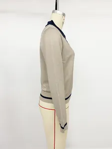 Detailed side view of beige women's long-sleeve knit sweater with navy contrast trim detail