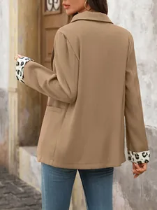 Een gedetailleerd achteraanzicht van een khaki blazer met luipaardprint manchetten