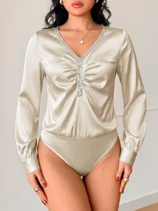 Detail van champagne satijnen bodysuit met V-hals, pailletten en geplooide voorkant