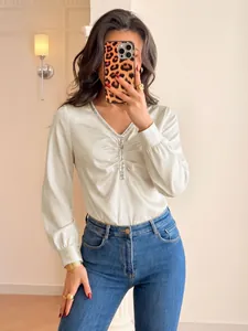 Elegante ivoren satijnen bodysuit met lange mouwen, V-hals en pailletten details