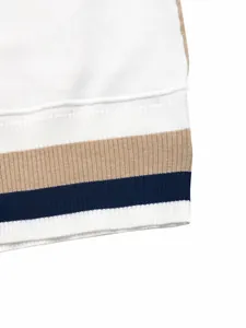 Detailed macro view of a knitted sweater's ribbed hem with navy and tan stripes