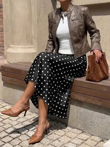 Elegant high-waist black midi skirt with white polka dots and a mermaid hemline detail.