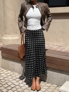 Stylish elegant high-waisted black and white polka dot mermaid midi skirt in a casual outdoor setting.