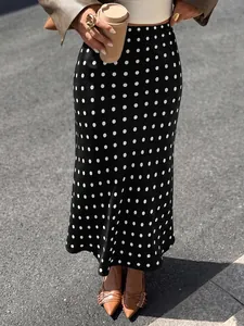 Detail view of high-waisted black polka dot mermaid midi skirt for women outfit