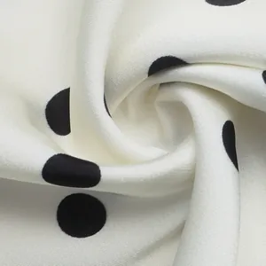Close-up macro detail of soft white satin fabric featuring classic black polka dot pattern