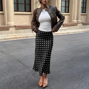 Elegant high-waisted black midi skirt with white polka dot pattern and mermaid hem