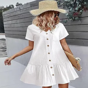 Vue détaillée d'une robe d'été boutonnée en coton et lin blanc à ourlet volanté.