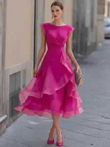 Elegante abito midi in mesh fucsia con balze e corpetto a pieghe indossato da modella.
