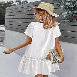 Vue arrière d'une robe d'été blanche en coton et lin avec ourlet à volants et coupe ample