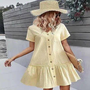 Vue détaillée en extérieur d'une robe jaune en coton et lin à boutons et volants.