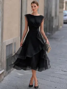 Vista a figura intera di un elegante abito nero in mesh a strati in una strada