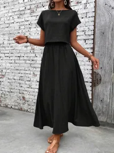 Elegant black two-piece summer outfit with a short sleeve top and a flowing maxi skirt.