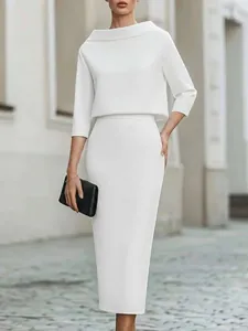 Detailed view of an elegant white two-piece set with a boat neck top and midi pencil skirt