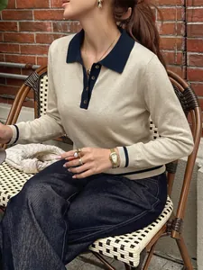 Detailed view of women's beige knit polo sweater with contrasting blue collar.