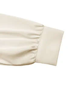 Close-up van geplooide satijnen manchetdetail van een elegante bodysuit