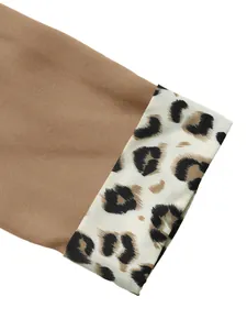 Macrodetail van de manchet met luipaardprint op een stijlvolle bruine blazerjas voor dames.