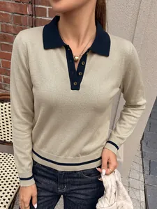 Detail view of elegant beige knit polo sweater featuring contrast navy blue collar and cuffs
