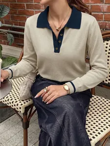 Detailed shot of a chic cream knit polo sweater featuring navy contrast collar and cuffs