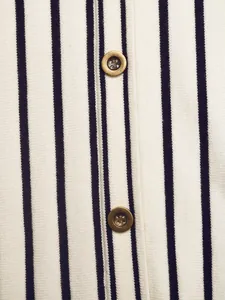 Close-up of black and white striped knit cardigan with vintage gold buttons