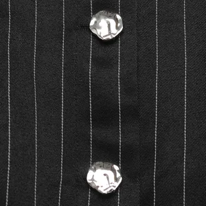 Macro view of unique silver metal buttons on black pinstripe women shirt fabric