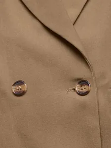 Detailopname van schildpaddenknoppen op een kaki zakelijke blazer