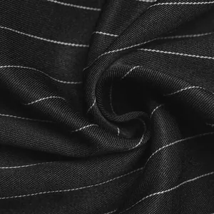 Macro detail of high-quality black pinstripe fabric texture for women's commuter shirt.