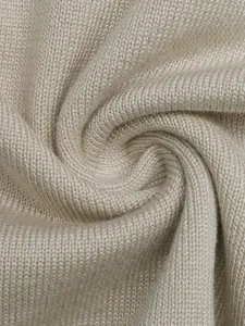 Close-up of soft beige knit fabric showing fine texture and ribbed pattern detail