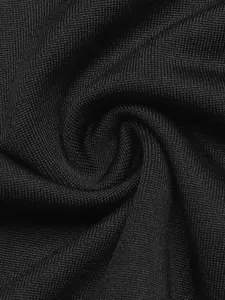 Close-up of black knitted fabric texture showing intricate woven pattern and twist detail.