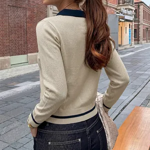 Elegant women's long-sleeved knit sweater with navy contrast trim shown from the back