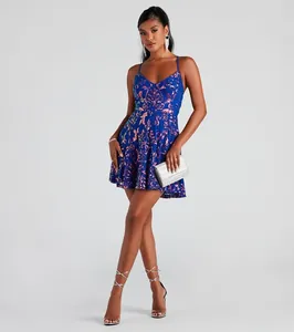 Full view of a blue sequin cocktail mini dress with spaghetti straps and silver clutch.