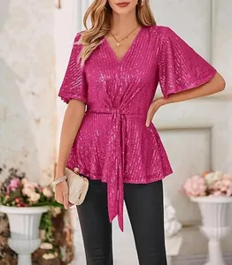 Detail of a fuchsia V-neck sequined blouse with tie-front and elegant flutter sleeves.