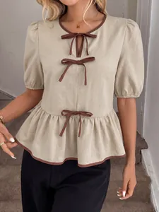 Elegante beige Bluse mit Puffärmeln, braunen Schleifendetails und einem gerüschten Schößchen