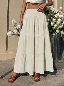 Close-up of elegant high-waisted smocked beige maxi skirt with a tiered A-line silhouette
