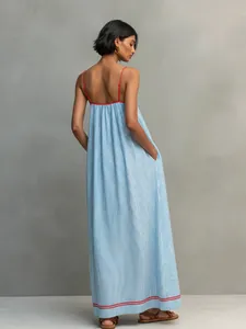 Vista trasera de vestido largo minimalista a rayas azules con tirantes rojos y bolsillos