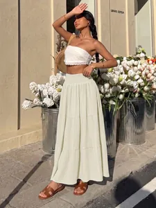 High-waisted cream tiered maxi skirt for women in a summery outdoor street style view