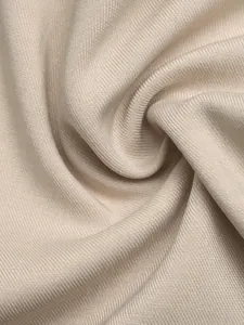 Nahaufnahme der beigen Textur und des Faltenwurfs eines eleganten Kurzarmhemdes