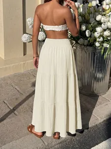 Detailed back view of an elegant cream tiered maxi skirt featuring a smocked high waistline