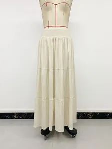 Detail view of cream high-waisted smocked A-line tiered maxi skirt on mannequin